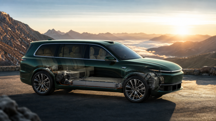 Zielony siedmioosobowy SUV EREV z widocznym napędem na górskiej przełęczy