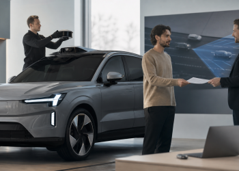 Elektryczny SUV w salonie podczas demontażu czujnika LiDAR i przekazania rekompensaty klientowi