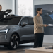 Elektryczny SUV w salonie podczas demontażu czujnika LiDAR i przekazania rekompensaty klientowi